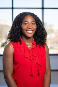 Headshot of a woman in a red shirt smiling