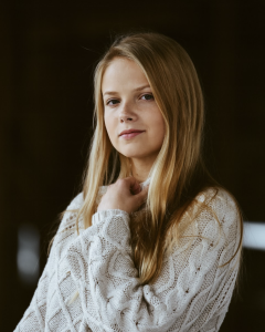 Headshot of a woman in a white sweater
