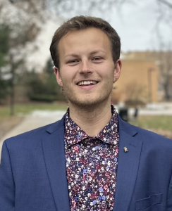Headshot of a man in a navy suit
