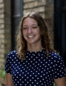Headshot of a woman in a blue polka dot shirt smiling