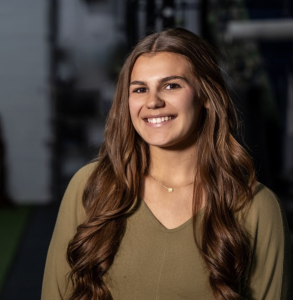 Headshot of a woman with a green shirt smiling