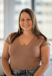 Headshot of a woman in a brown shirt