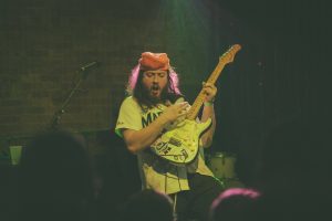 Stuart Benjamin playing a guitar.