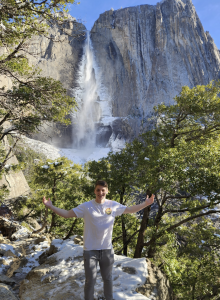 Photo of a man in front of a waterfall