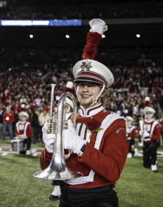 Photo of a man in a marching band uniform smiling