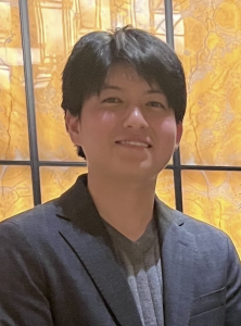 Headshot of a man in a grey blazer