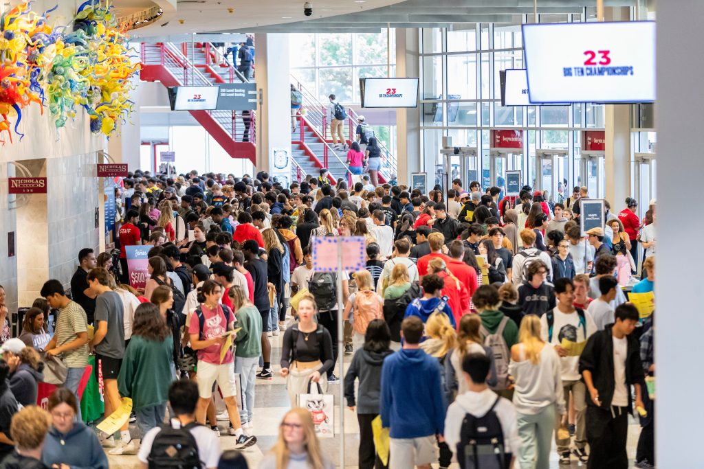 Overhead image of students walking through the Kohl Concourse to talk to organizations during the Fall Student Organization Fair at the Kohl Center