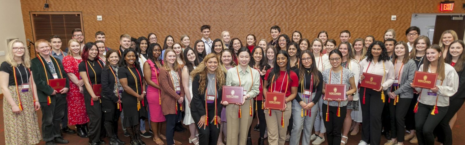 Group photo of leadership certificate recipients holding their red diploma covers.
