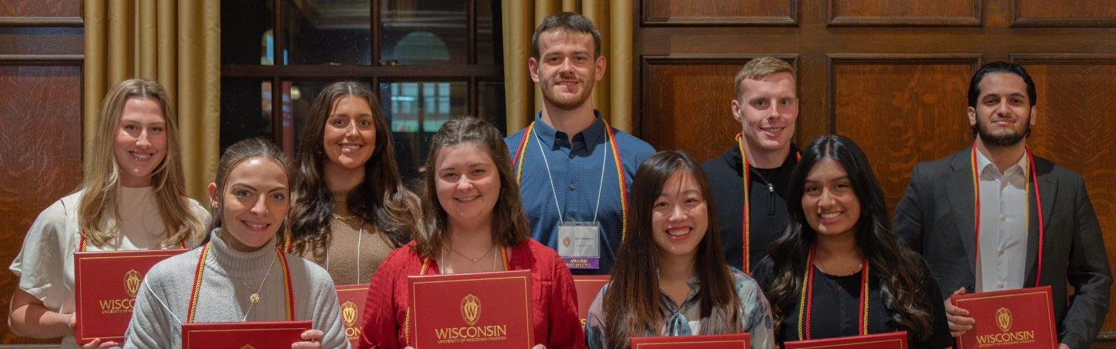 Group photo of leadership certificate recipients holding their red diploma covers.
