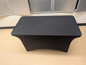A four-foot table fully covered by a black table lay.