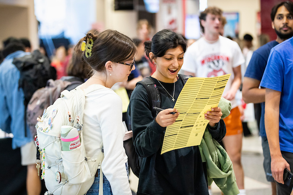 2 students look at the map of student organizations during the Fall Student Organization Fair at the Kohl Center at the University of Wisconsin–Madison on Sept. 8, 2023.