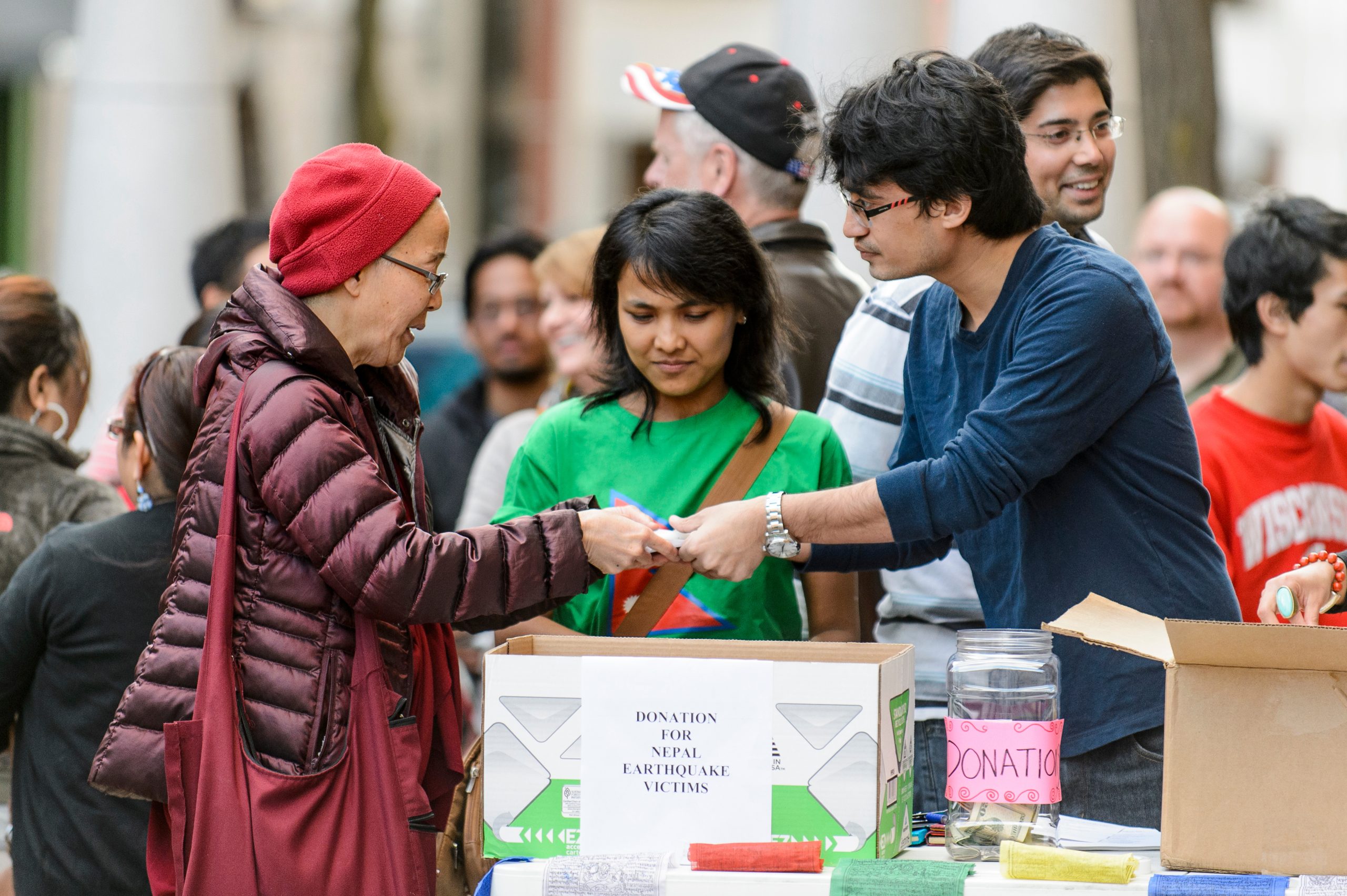 Members of the UW Nepal Student Association hand out candles as Madison community members gather near the State Capitol for a candlelight vigil