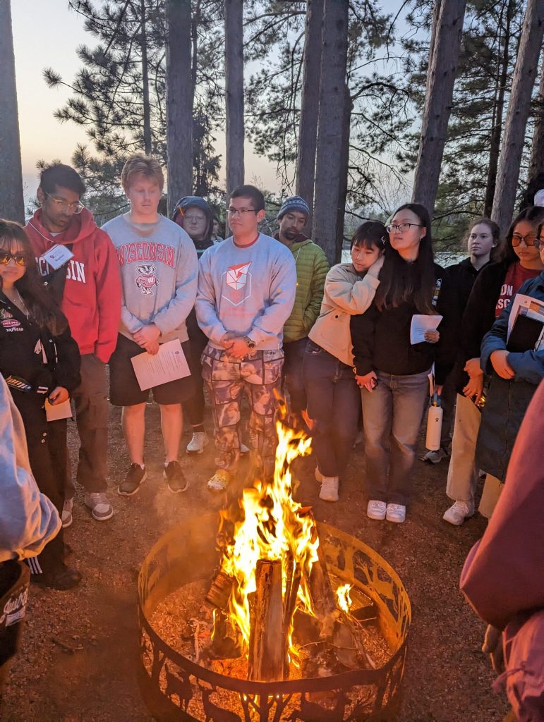 A group of WEBT students standing around a bonfire.