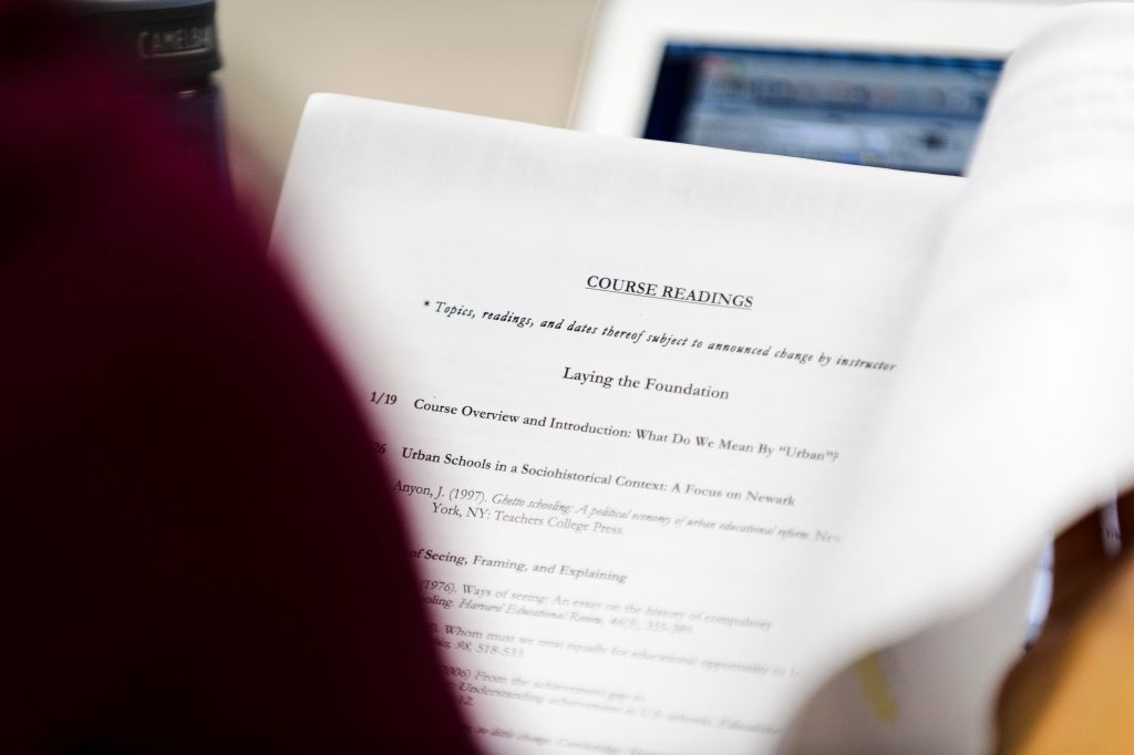 Looking over a student's shoulder at printed course material.
