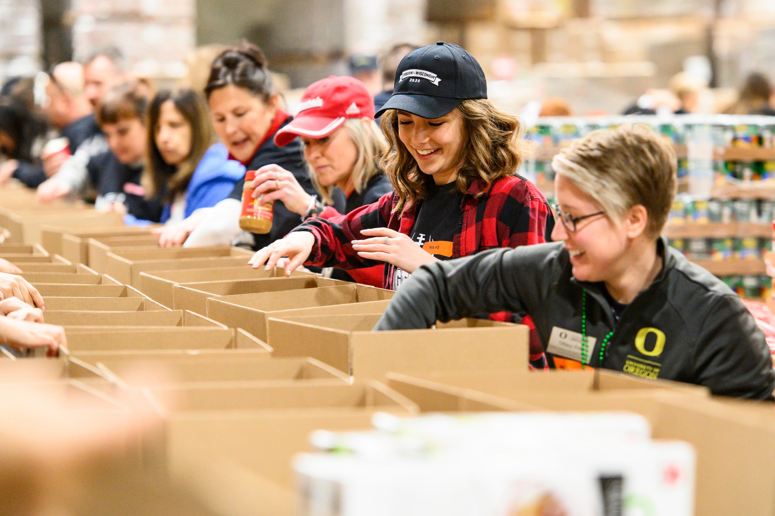 UW alum fill boxes with canned goods. The service project was a collaboration between UW-Madison and University of Oregon before the 2020 Rose Bowl Game.