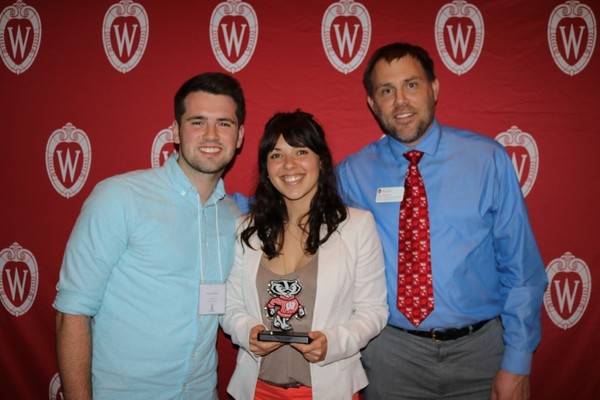 Group of three people posing with an award.