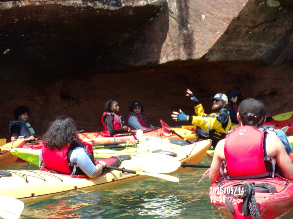 2025 WEBT students listening to their tour guide while on their sea kayaking tour at Romans Point.
