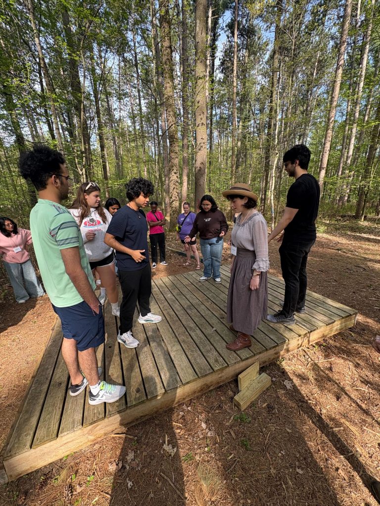 An outdoor shot of a group of 2025 WEBT students participate in a challenge course activity at the Central Wisconsin Environmental Station.