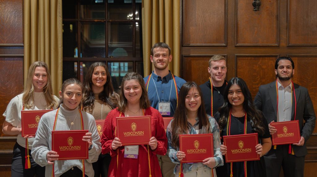 Group photo of leadership certificate recipients holding their red diploma covers.