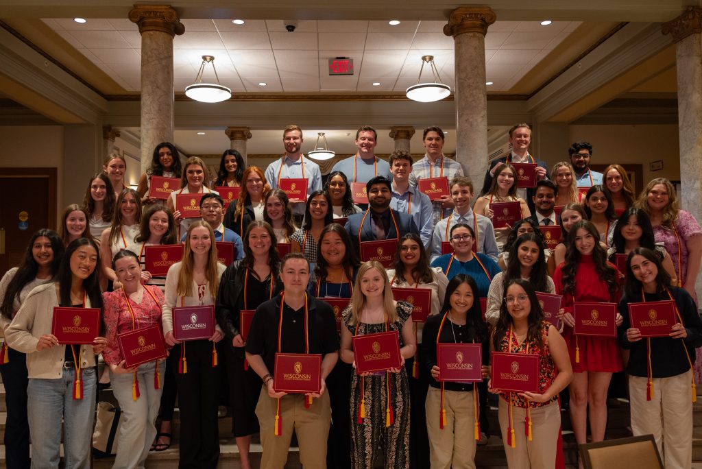 Group photo of leadership certificate recipients holding their red diploma covers.