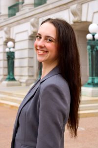 A woman in a grey blazer smiling