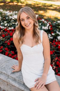 A woman in a white dress smiling