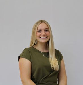 A woman in a green shirt smiling