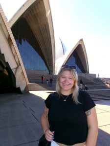 Woman smiling with buildings in the back