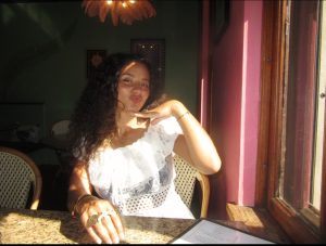 Woman smiling and holding hand up to chin