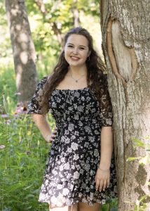 Woman smiling against tree