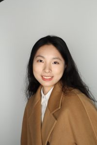 Woman smiling wearing a brown jacket
