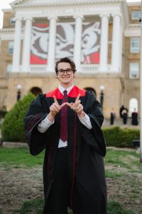 Man smiling in graduation gown